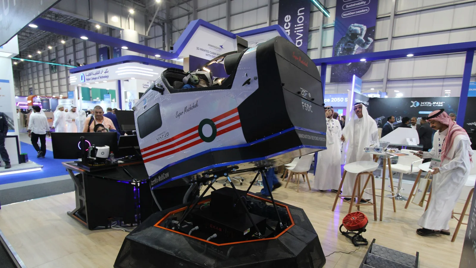 A visitor flying the AeroMix Super Mushshak mixed-reality simulator with an FSDC engineer at Dubai Airshow 2025