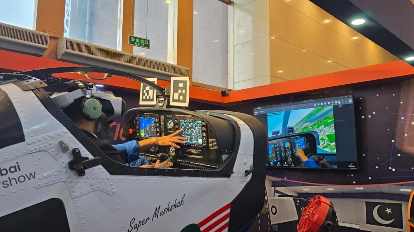 The Super Mushshak simulator cockpit with mixed-reality tracking markers and the visual channel behind it