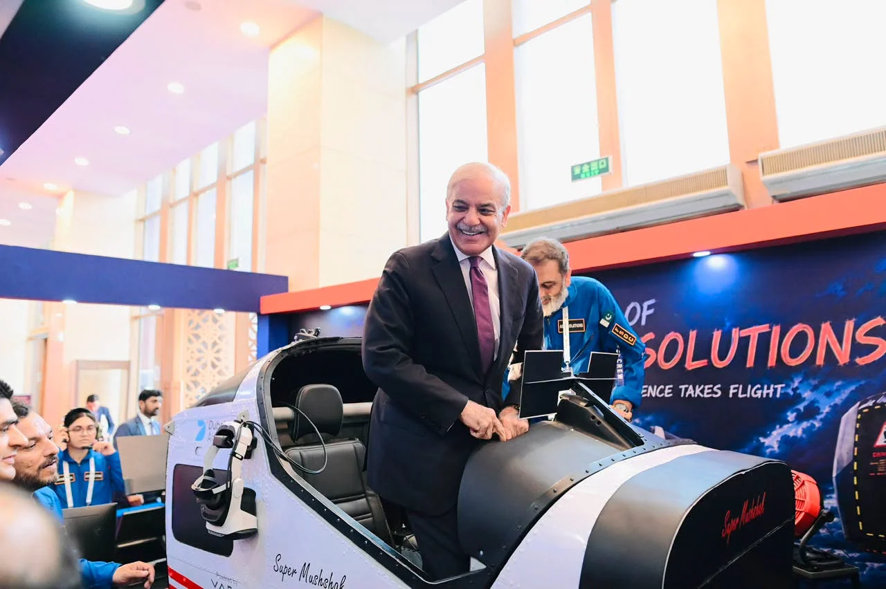 Pakistan's Prime Minister at the open cockpit of the AeroMix Super Mushshak simulator, being briefed by the FSDC team