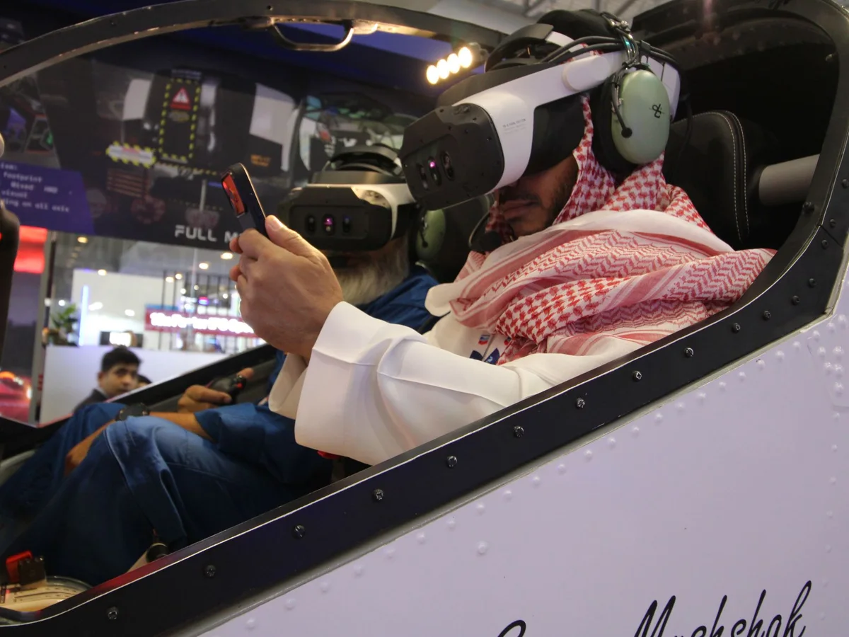 A guest flying the AeroMix simulator in a Varjo XR headset at Dubai Airshow 2025