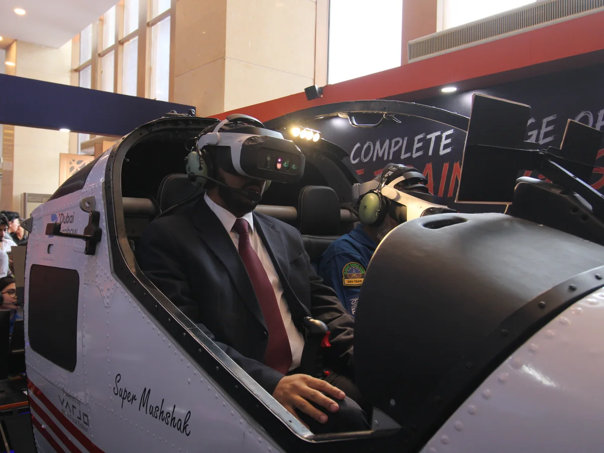 A guest seated in the Super Mushshak simulator cockpit