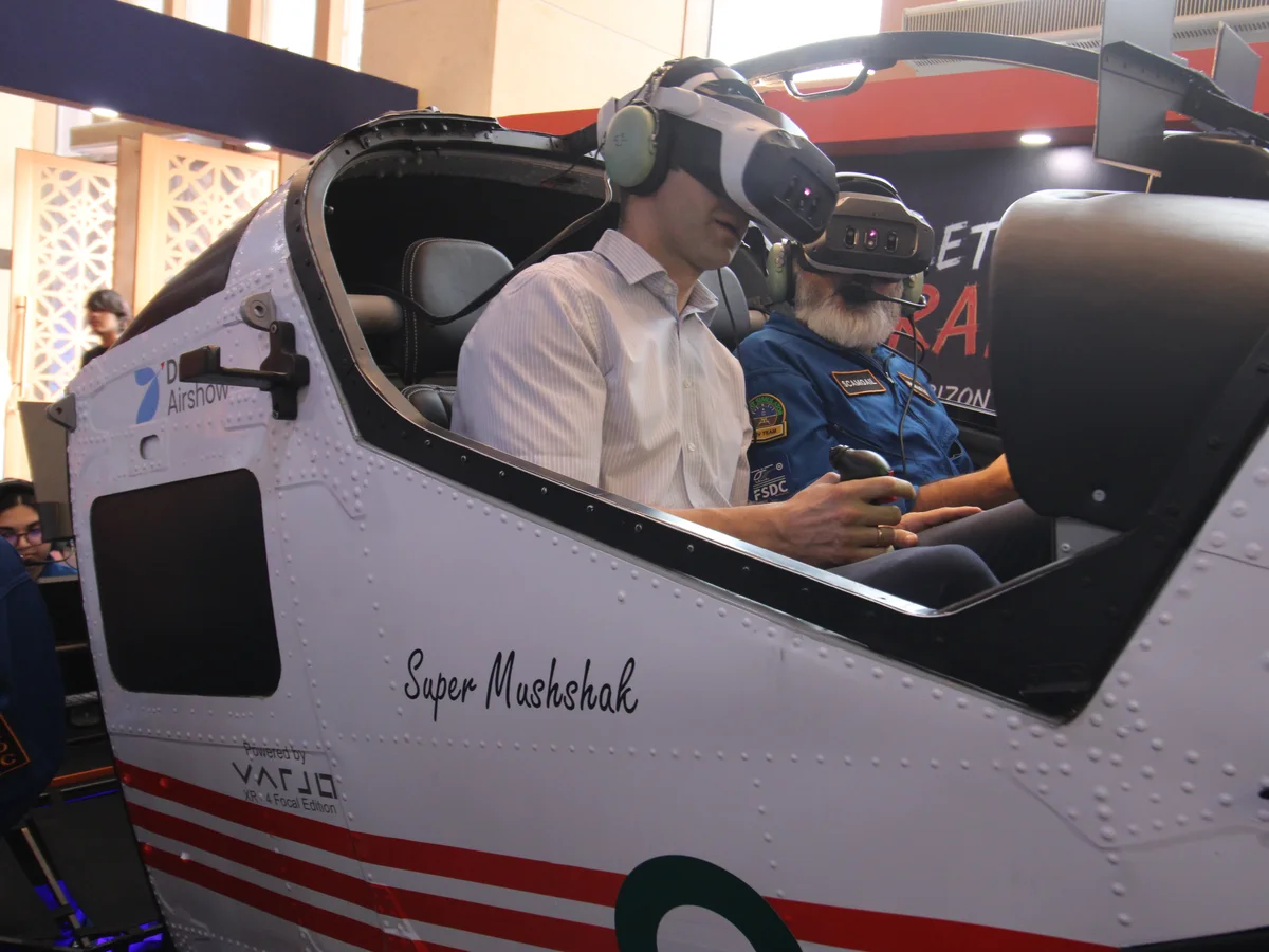 A visitor flying the Super Mushshak simulator in a mixed-reality headset